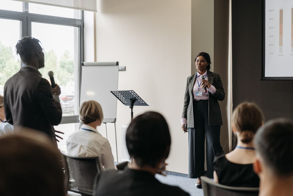 Professional business conference presentation with diverse participants engaging in communication.